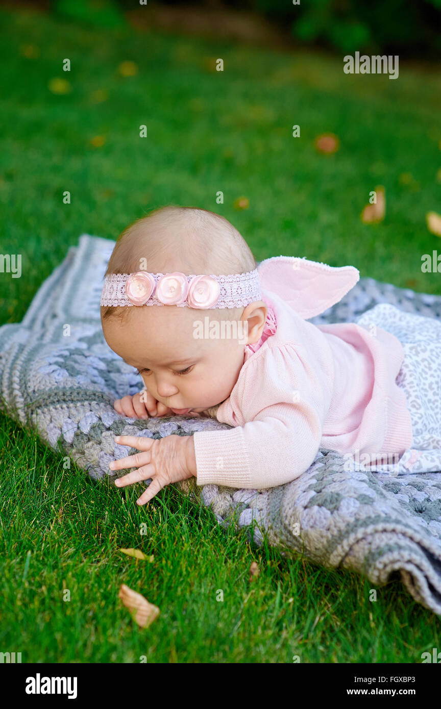Kleine Mädchen spielen auf dem Rasen im Sommerpark Stockfoto