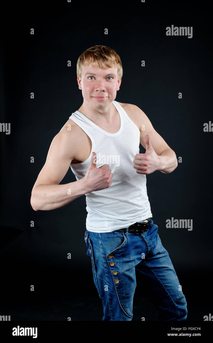 Gut aussehender Mann mit weißen leeren T-shirt mit dunklen Grunge Wand Stockfoto