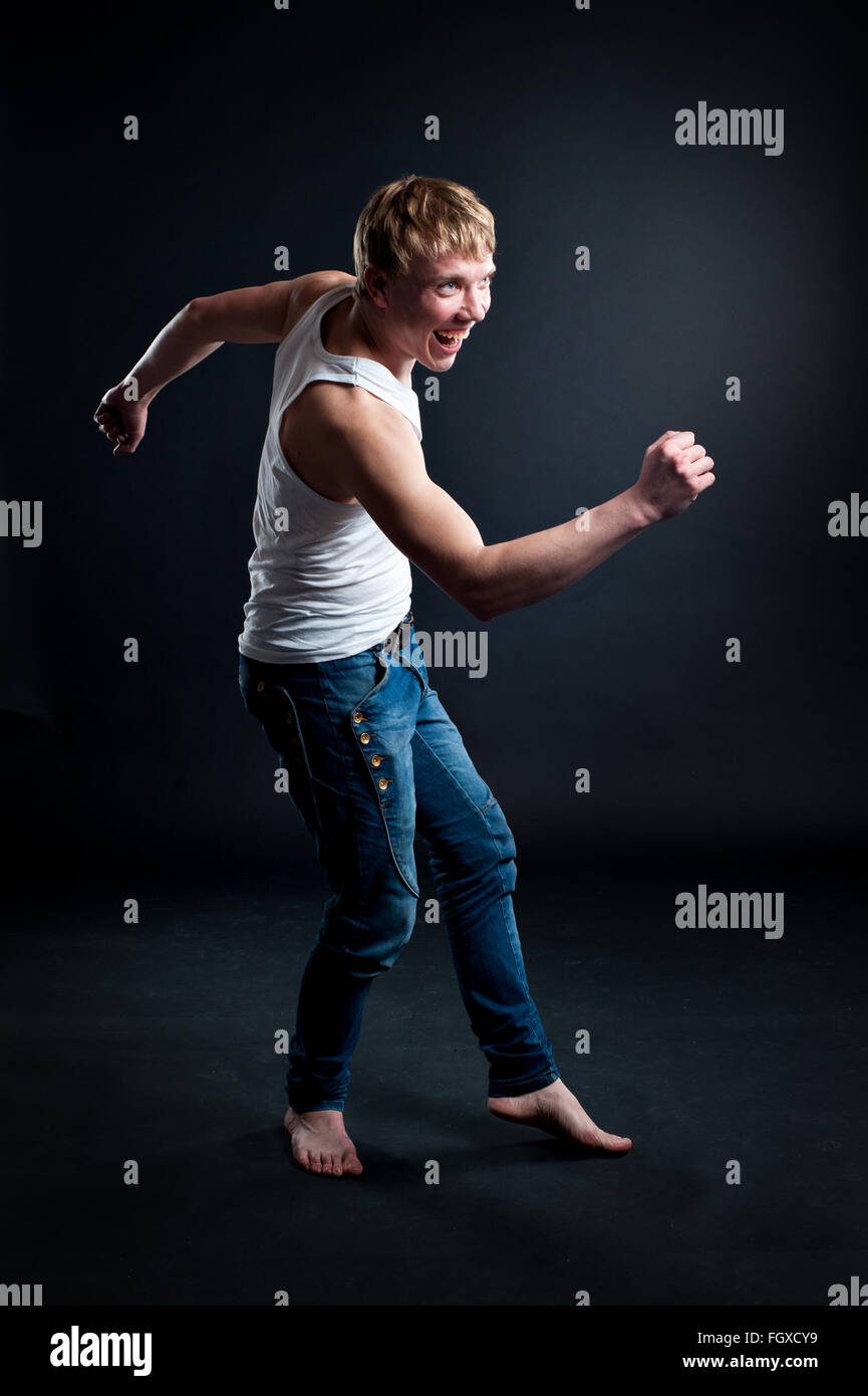 Gut aussehender Mann mit weißen leeren T-shirt mit dunklen Grunge Wand Stockfoto