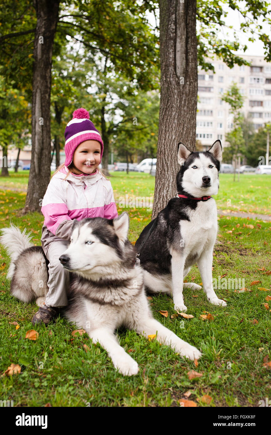 kleine süße Mädchen spielen mit husky Hund draußen im grünen park Stockfoto