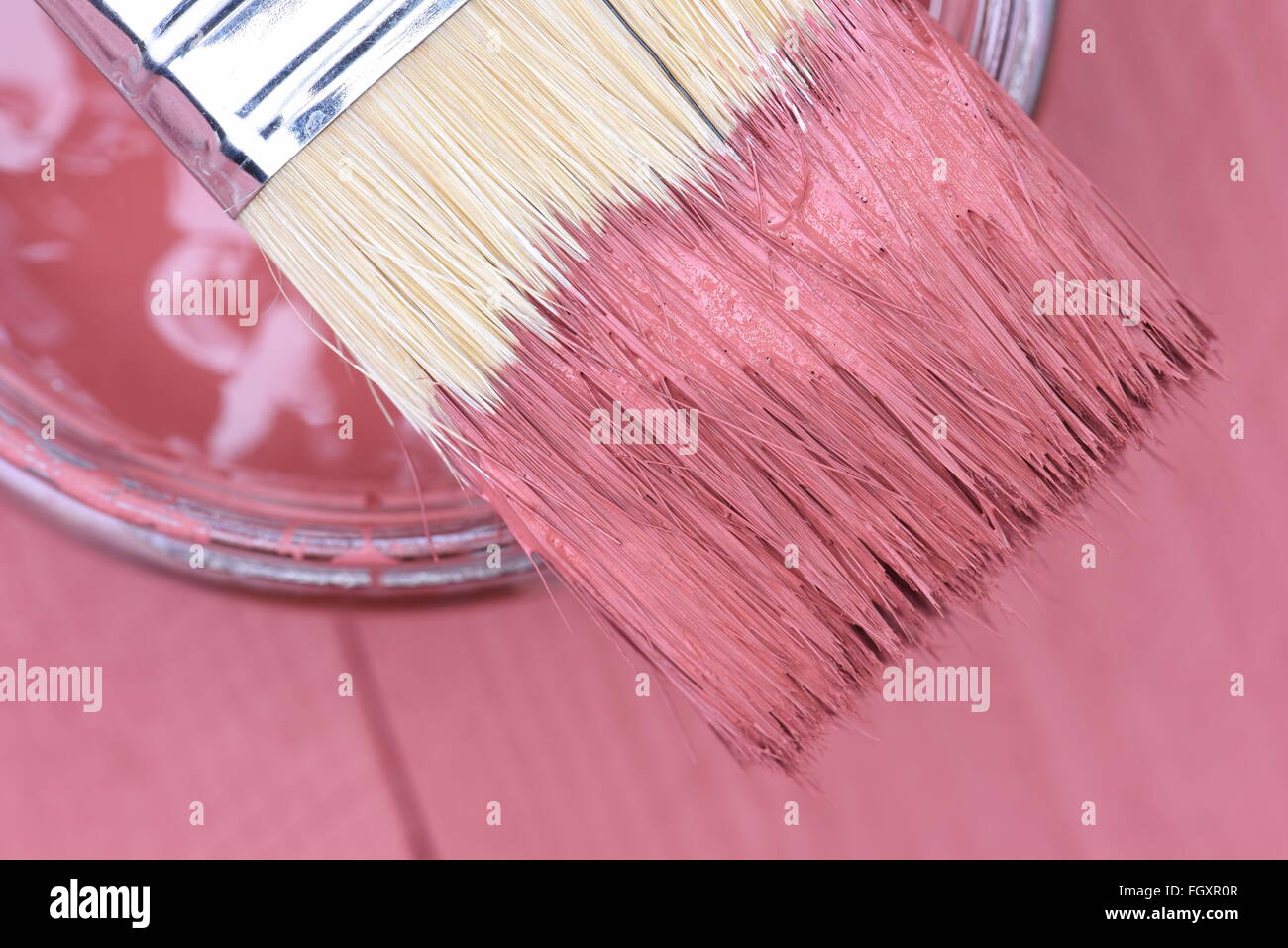Rosa Farbe in ein Glas mit Pinsel auf Holzbrett Hintergrund Stockfoto