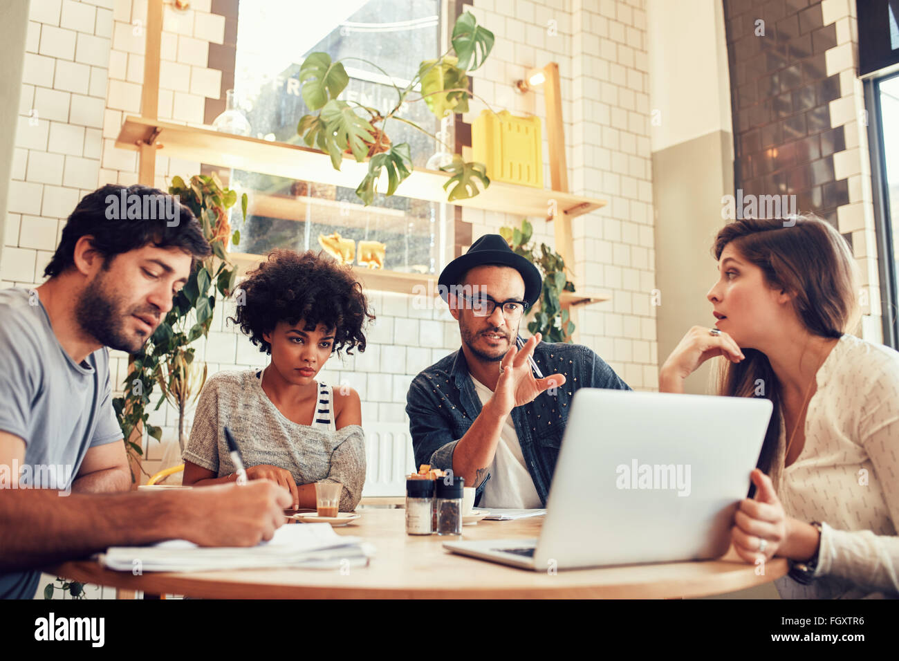 Portrait über kreative Business-Team sitzt in einem Café mit Laptop. Junger Mann neue Geschäftsideen mit Kollegen diskutieren Stockfoto