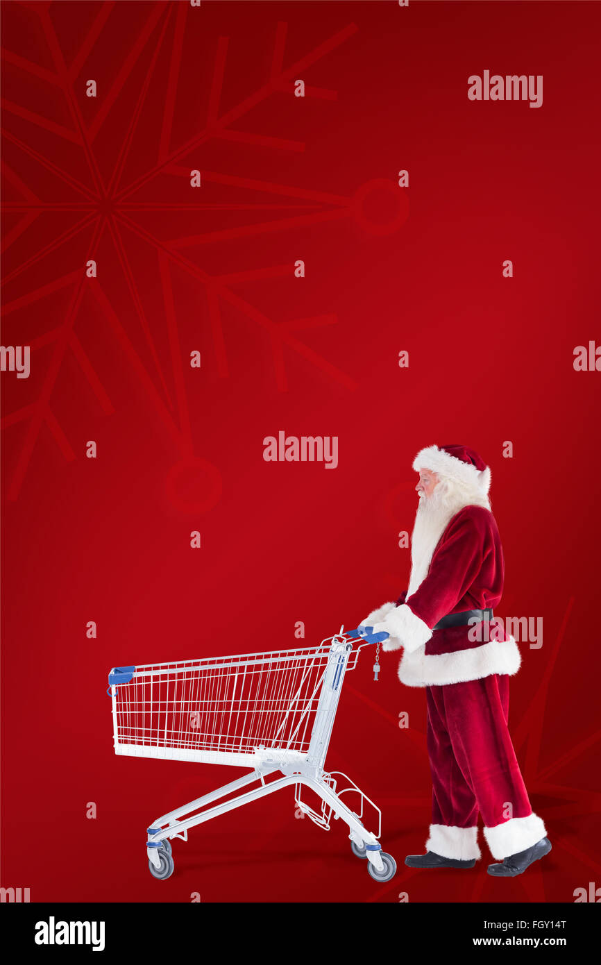 Zusammengesetztes Bild von Santa schiebt einen Einkaufswagen Stockfoto