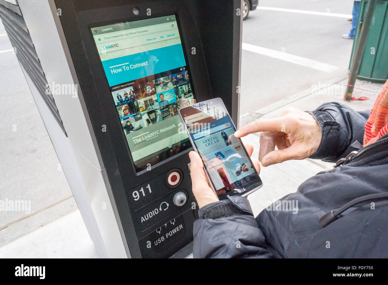 Eine Frau benutzt einen LinkNYC Kiosk Zugriff auf das Internet über ihr Smartphone in New York auf Samstag, 20. Februar 2016. Mehr als 7500 Kioske sind zu installierten ersetzen Stand allein Münztelefon Kioske bieten kostenfreies WLAN, Internet-Zugang über einen Touch-Screen, Telefon geladen und kostenlos telefonieren. Das System soll durch Werbung auf den Seiten der Kioske unterstützt werden. (© Richard B. Levine) Stockfoto