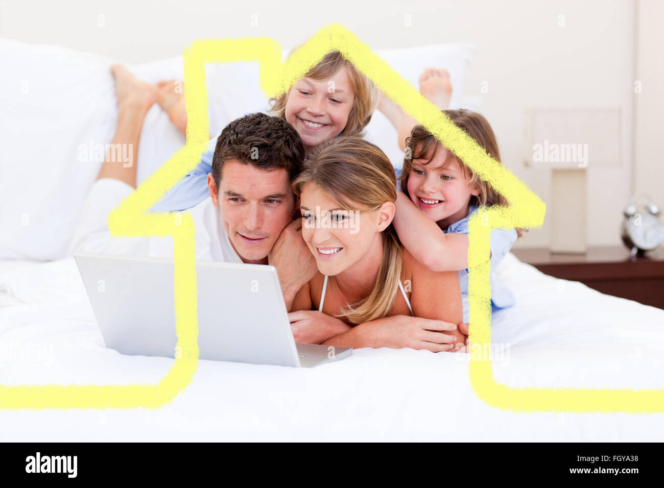 Zusammengesetztes Bild der liebenden Familie mit Blick auf einen Laptop auf dem Bett liegend Stockfoto