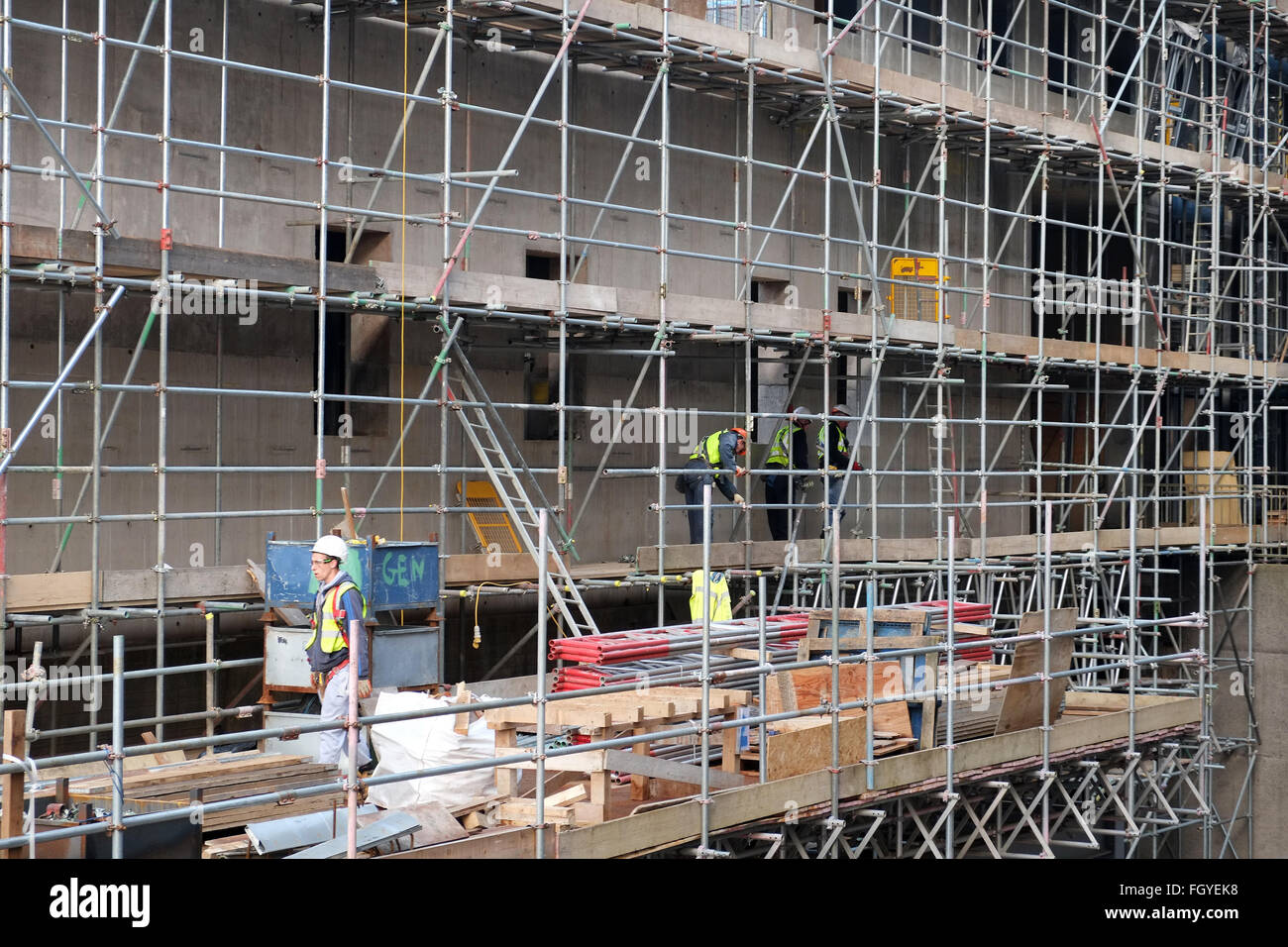 Männer bei der Arbeit auf einem Gerüst zu einem Hochhaus-Projekt in Bristol, England, UK GB Stockfoto