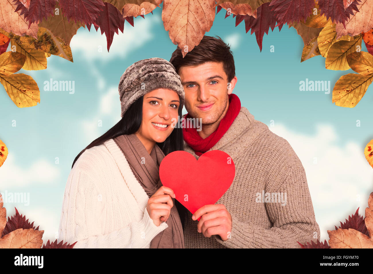 Zusammengesetztes Bild jungen Paares lächelnd hält rotes Herz Stockfoto