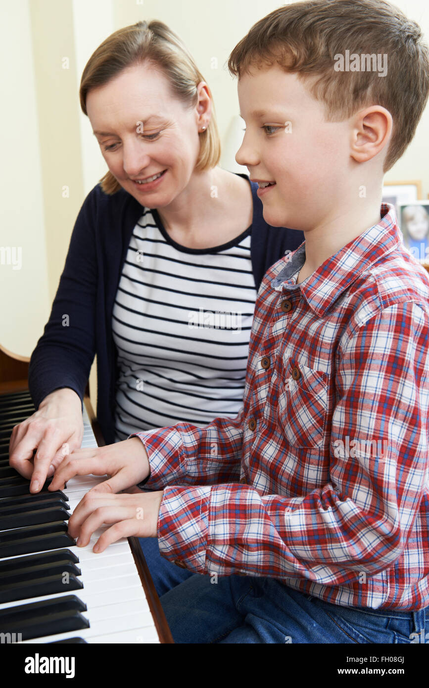Junge mit Musiklehrer mit Unterricht am Klavier Stockfoto
