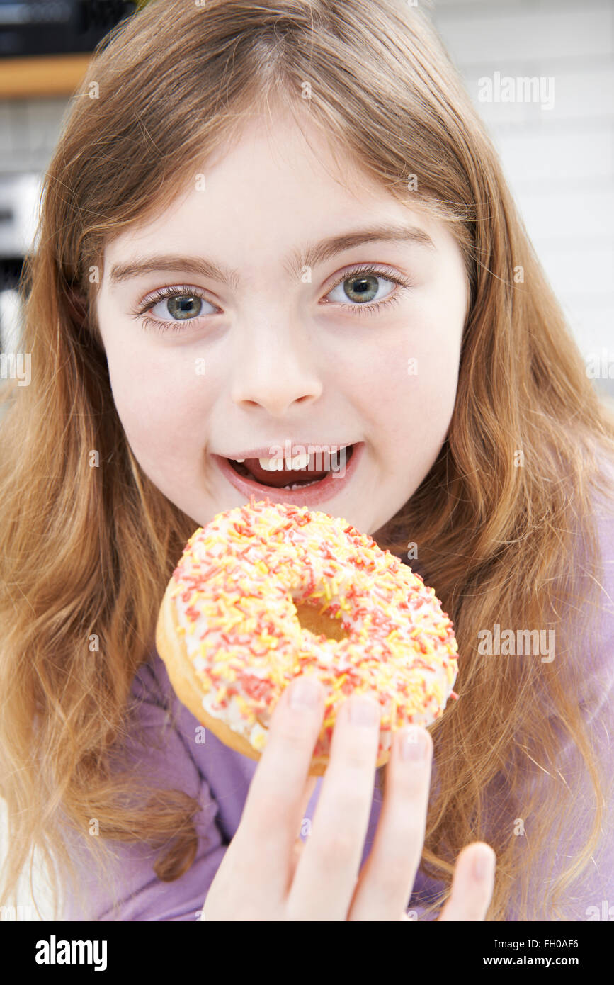 Junges Mädchen essen zuckerhaltige Donut für Snack Stockfoto