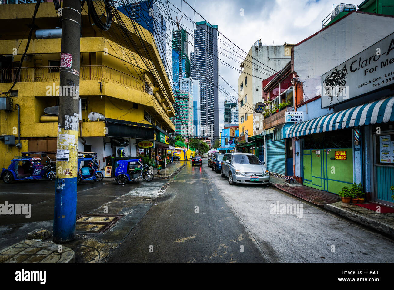 Eine schmale Straße und entfernten Wolkenkratzer in Poblacion, Makati, Metro Manila, Philippinen. Stockfoto