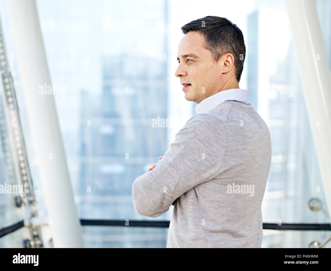 Kaukasische Geschäftsmann stehen und denken durch die Fenster im Büro Stockfoto