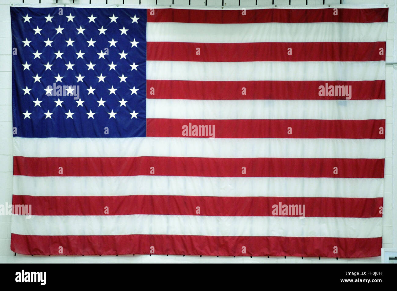 Eine große amerikanische Flagge auf dem Display an der Wand in einem Illinois High School Gymnasium. Bartlett, Illinois, USA. Stockfoto