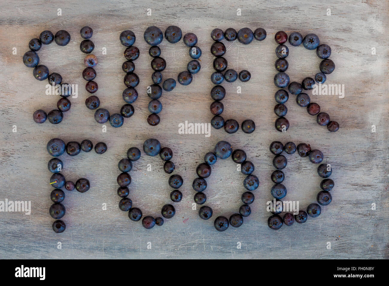 Super Essen-Text geschrieben mit Heidelbeeren Stockfoto
