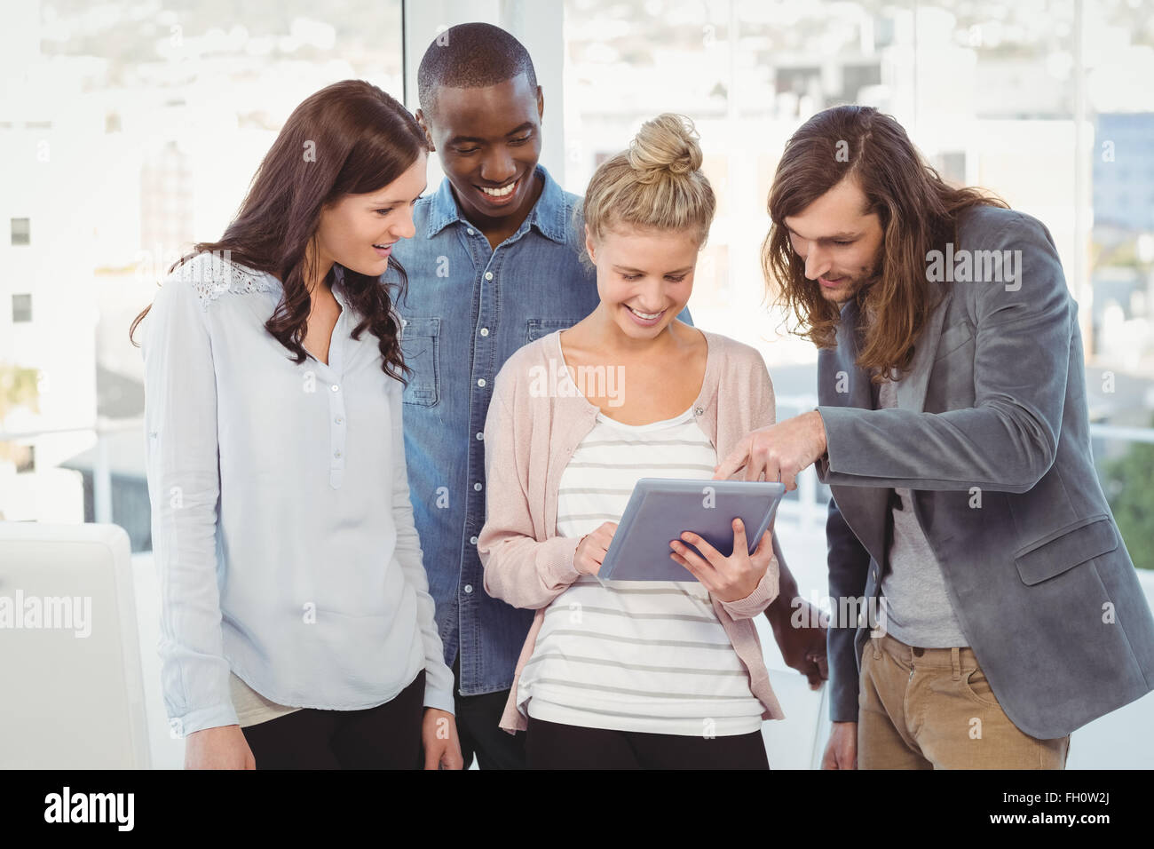 Glückliche Frau holding digital-Tablette und diskutieren mit Kollegen Stockfoto