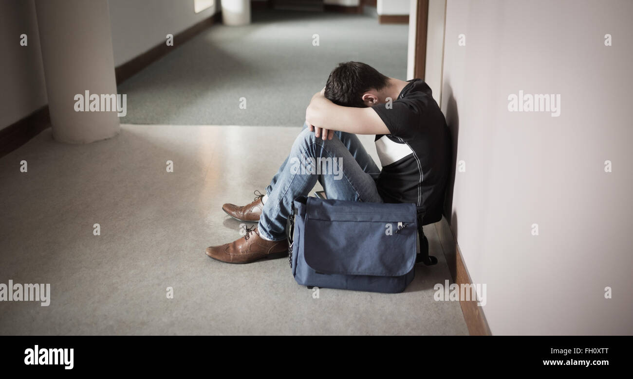 Depressiven männlichen Studenten mit Kopf auf Knie Stockfoto