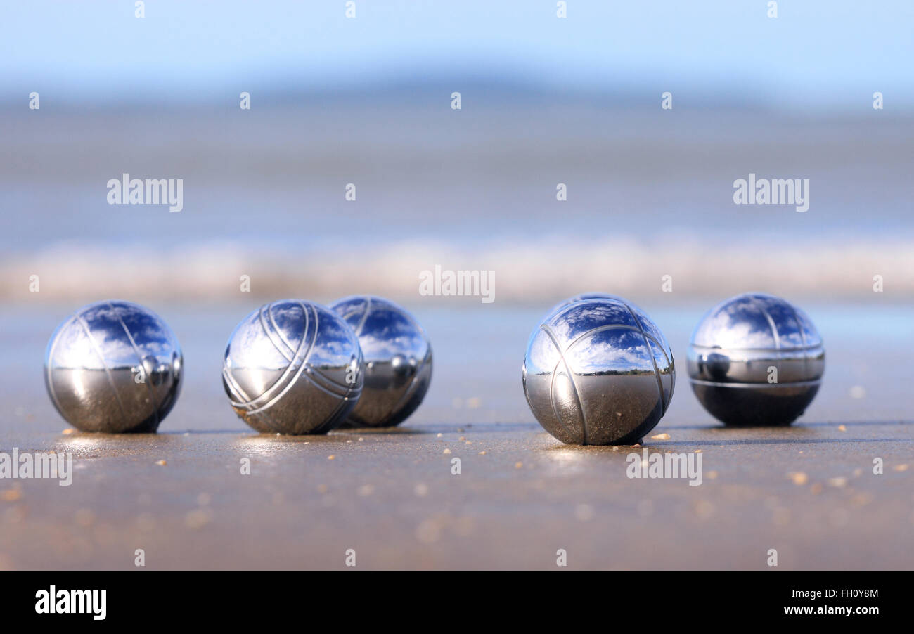 Eine Reihe von Stahl Petanque Kugeln an einem Sandstrand. Stockfoto