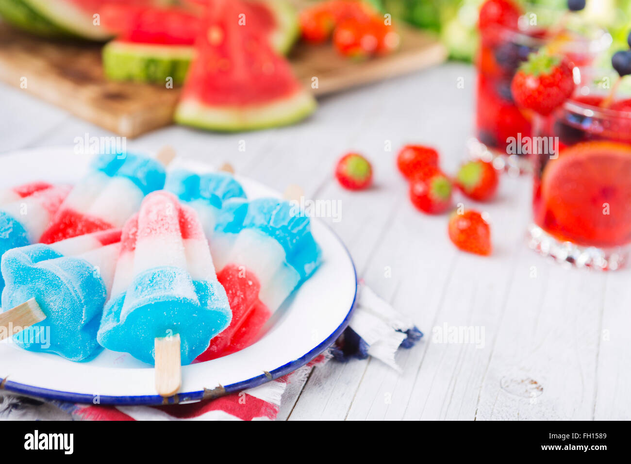 Hausgemachte rot-weiß-blauen Eis am Stiel auf einen Tisch im Freien mit erfrischenden Limonade im Hintergrund. Stockfoto