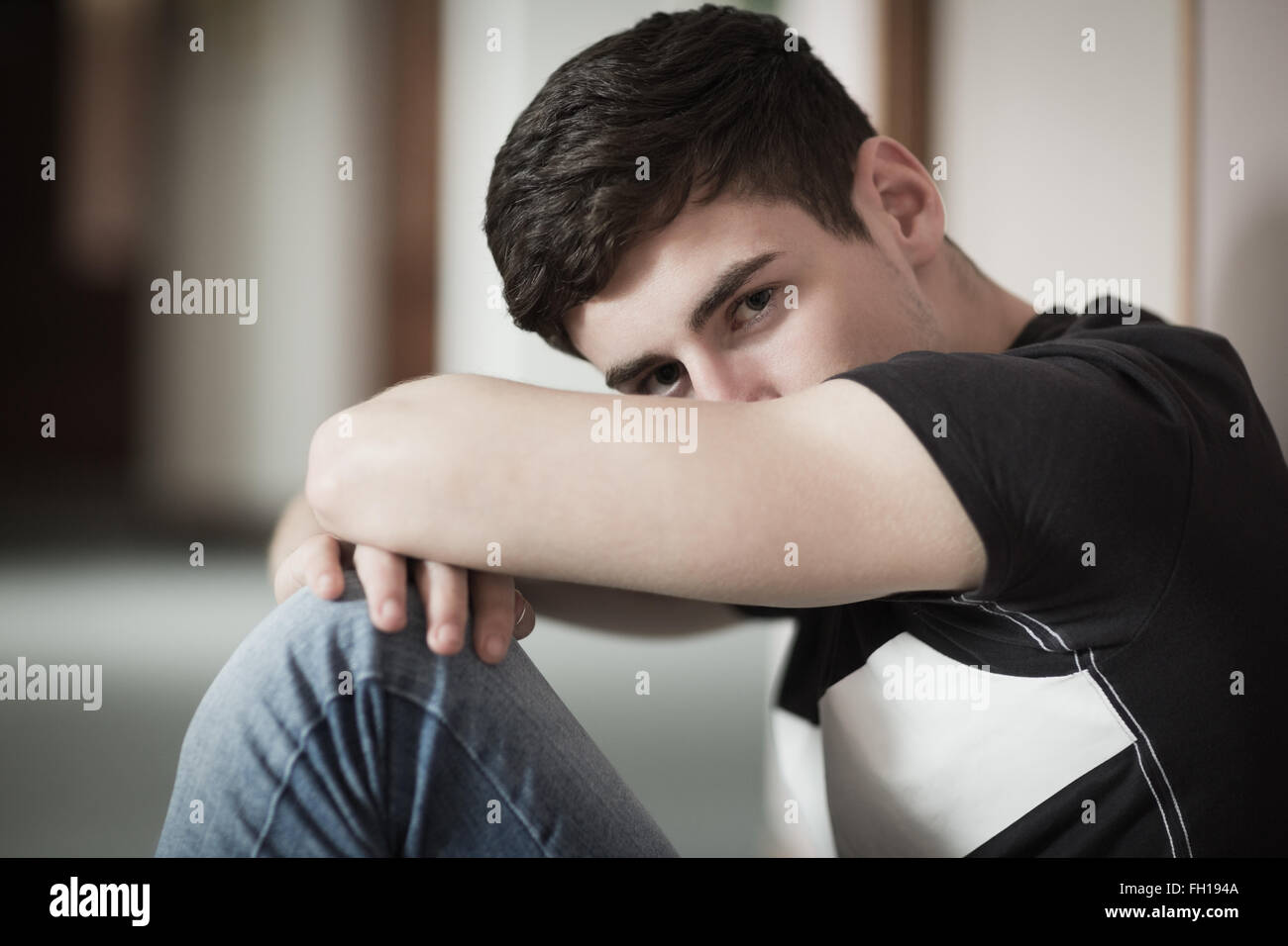 Close-up Portrait von männlichen Studenten mit Kopf auf Knie Stockfoto