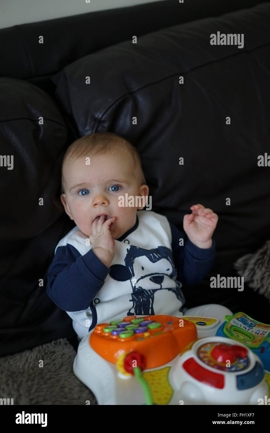 Sechs Monate Baby Bug sitzen aufrecht spielen mit lernen Zentrum Spielzeug, UK. Stockfoto