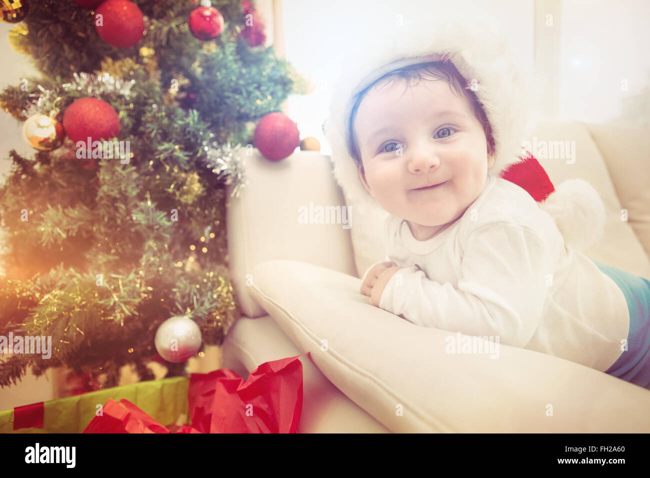 Niedliche Baby Boy auf Couch zu Weihnachten Stockfoto