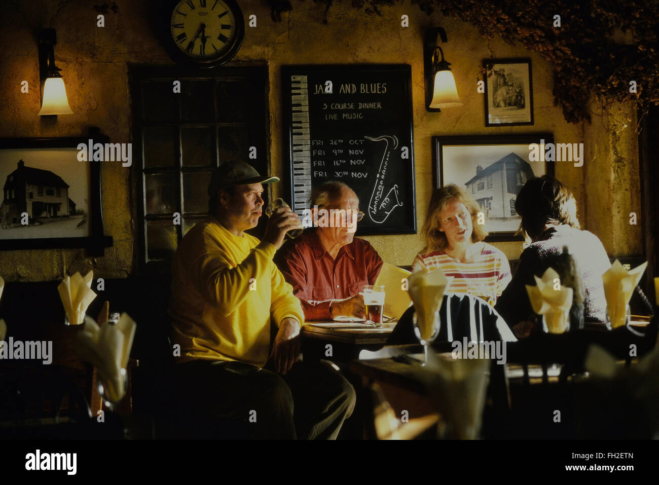 Eine Gruppe von Erwachsenen sitzen in einem Pub genießen Sie einen Drink und einen Chat. Kent. England. UK Stockfoto