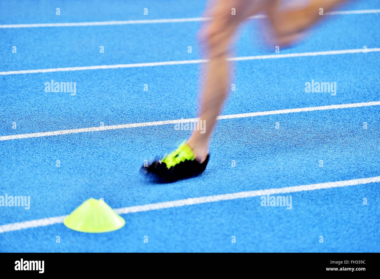Verschwommene Athleten durch eine langsame Kamera Verschlusszeit auf blaue Sprint Track zu konkurrieren Stockfoto