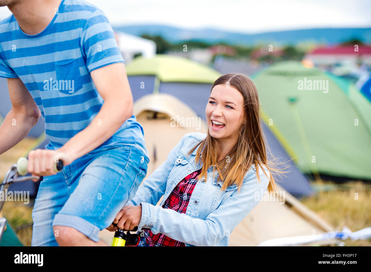 Teenager-Paar Reiten Fahrrad zusammen im Sommer-Musikfestival Stockfoto