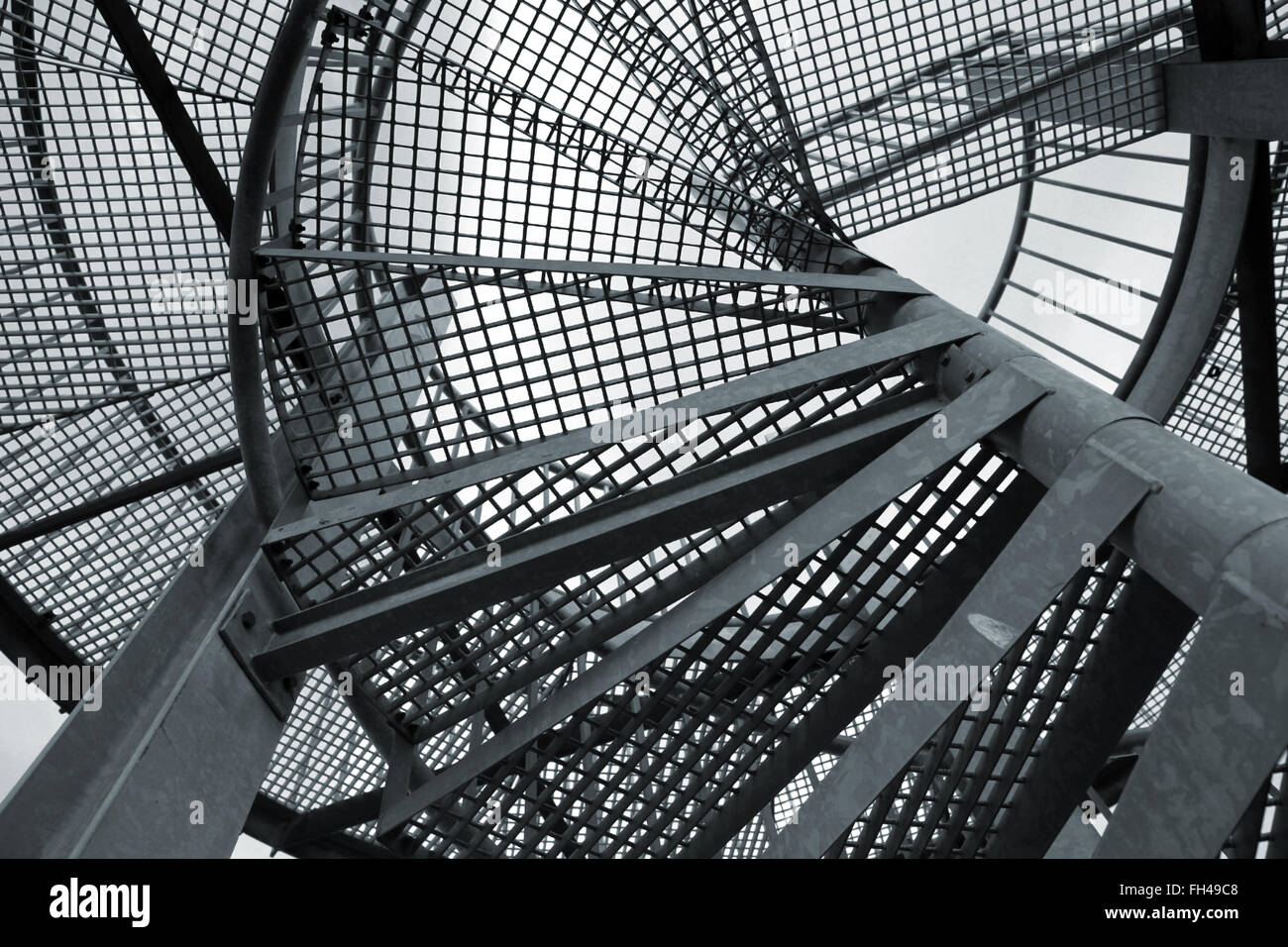 Abstrakte Industrieerfahrung mit Stahlspirale Leiter Fragment, blau getönten Foto Stockfoto