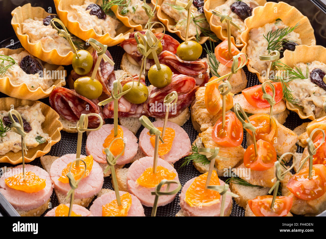 Closeup setzen verschiedene Häppchen und Snacks in Kunststoff schwarz Form für mobiles catering Stockfoto