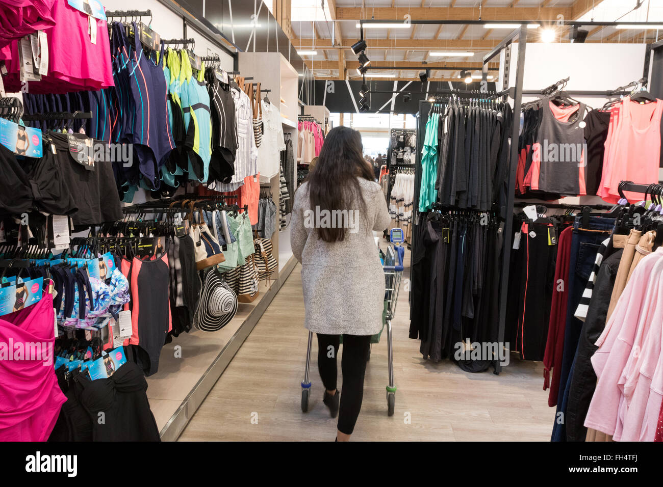 Eine Frau shopping für Kleidung in einem Tesco Extra Supermarkt Laden, Suffolk UK Stockfoto
