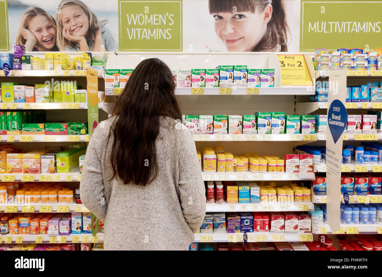 Frau Einkaufen in einem Supermarkt Chemiker Bereich für Gesundheit der Frauen Produkte und Vitamine, Tesco Suffolk UK Stockfoto