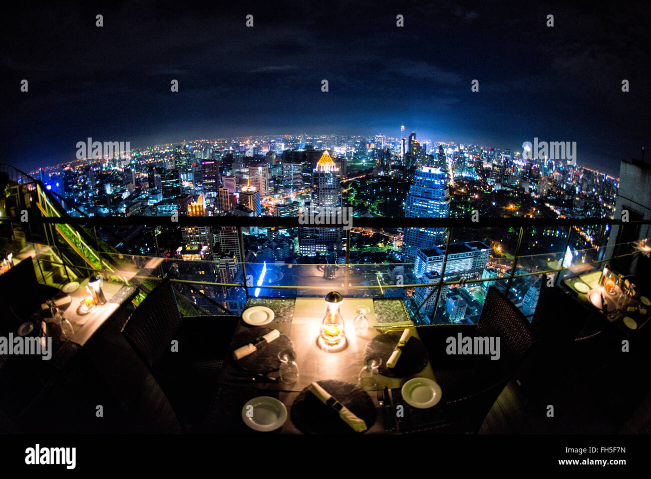 Bangkok Skyline bei Nacht vom Banyan Tree Hotel Thailand // BANGKOK, Thailand – die glitzernde Skyline von Bangkok erstreckt sich unterhalb des Hotels, vom Restaurant Vertigo auf der Dachterrasse auf dem Banyan Tree Hotel aus. Wolkenkratzer und Hochhäuser beleuchten die weitläufige thailändische Hauptstadt mit unzähligen Lichtern und schaffen ein atemberaubendes Stadtpanorama. Stockfoto