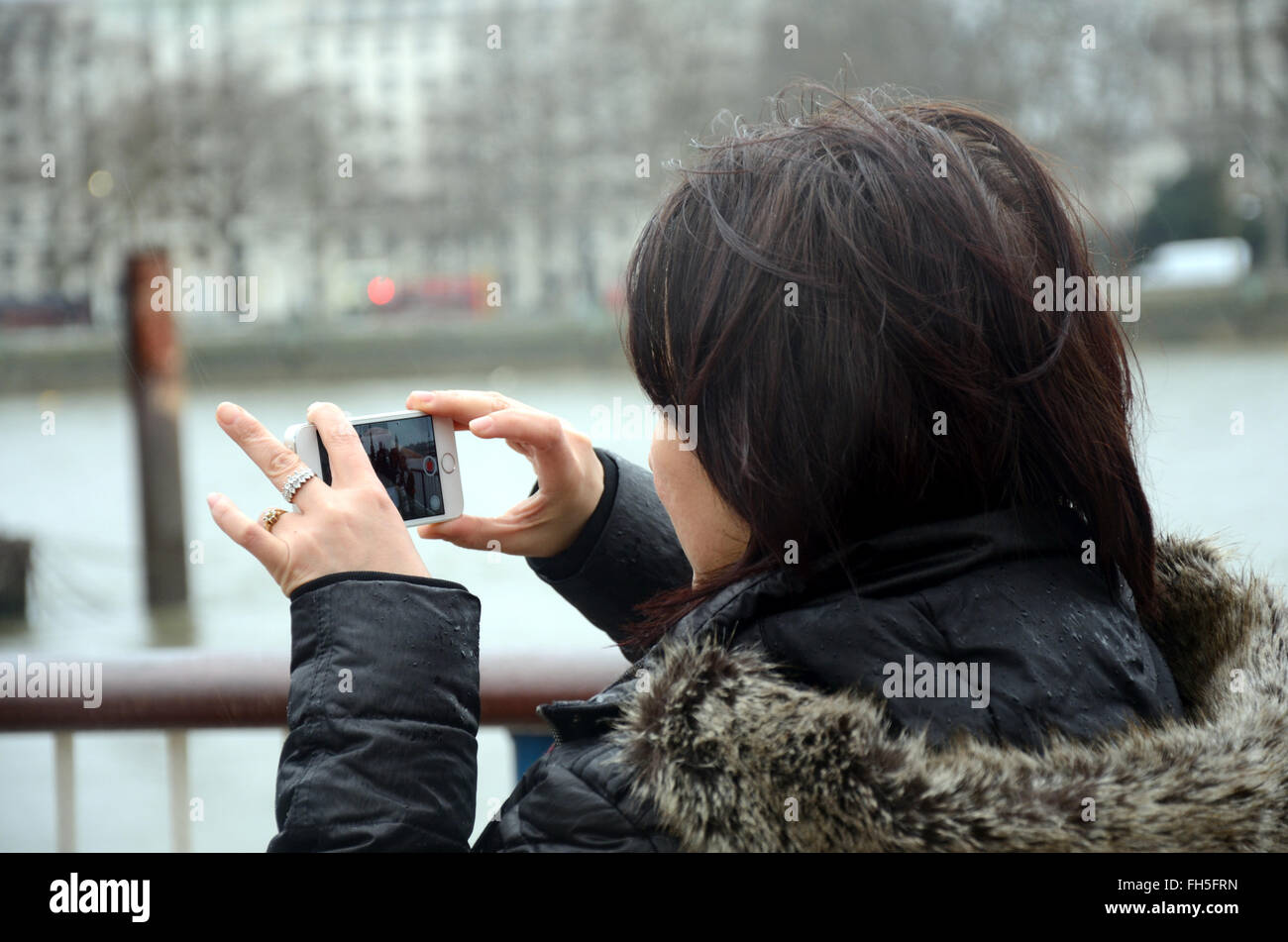 Eine Frau nimmt ein Bild auf ihrem iPhone. Stockfoto