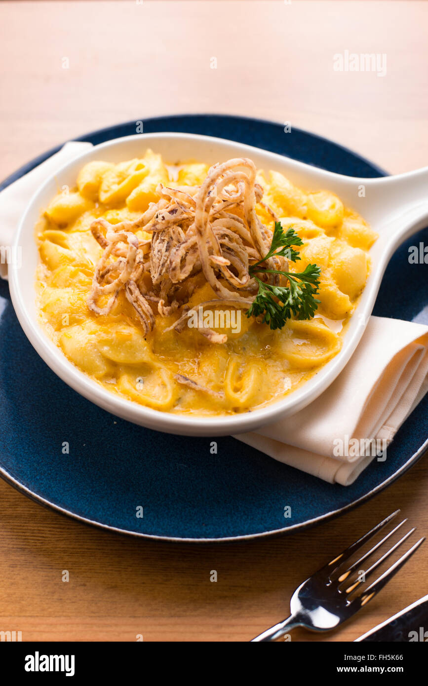 Eine 3/4 seitlicher Blick auf Trüffel Makkaroni und Käse garniert mit knusprigen Zwiebeln. Stockfoto