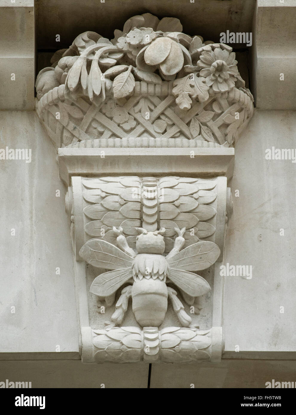 Geschnitzten Stein Corbel oder Schlussstein am Eingang zum Honig Lane London EC2 in der Nähe von Cheapside Darstellung einer Biene und einem Korb voller Blumen Stockfoto
