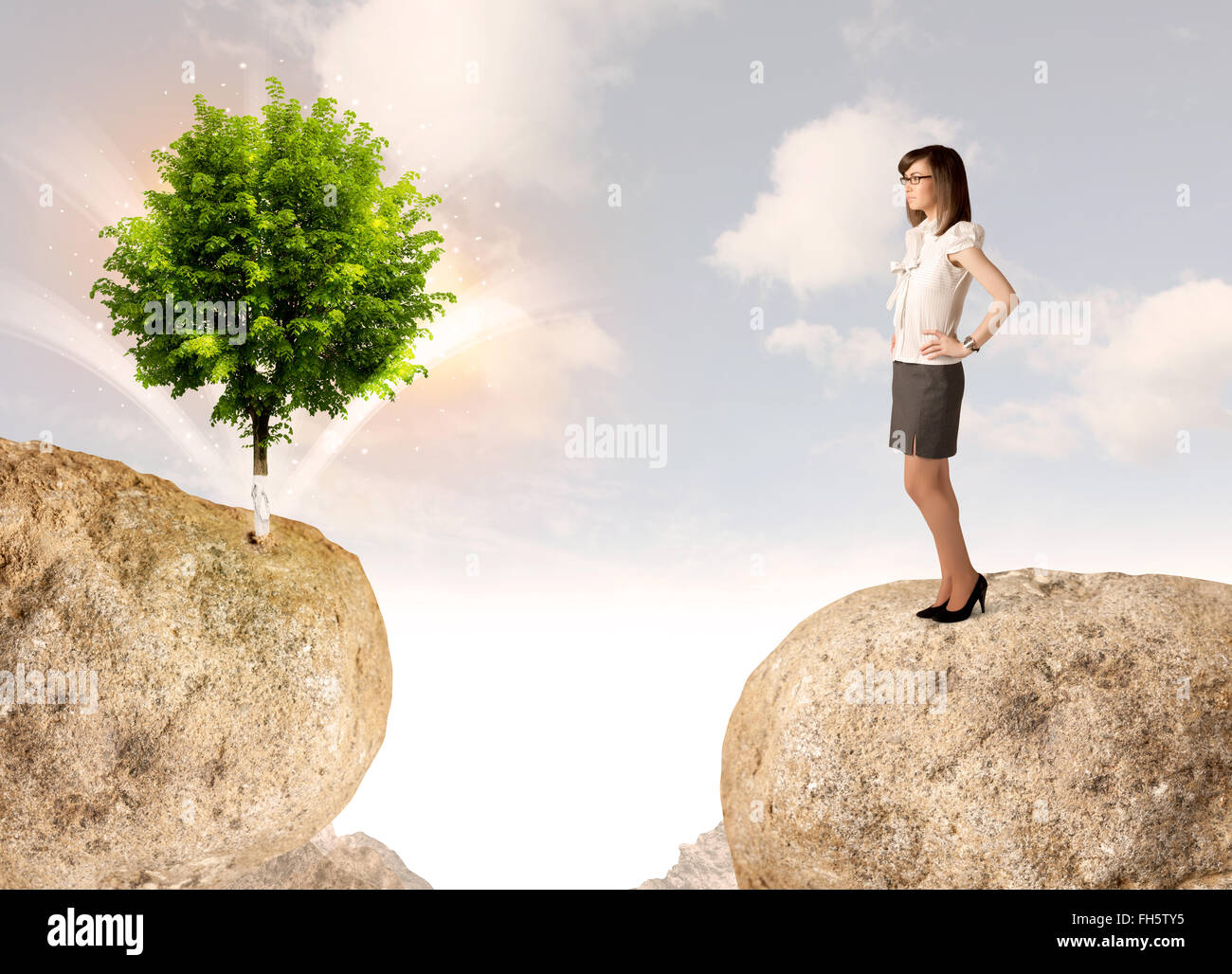 Geschäftsfrau auf Fels-Berg mit einem Baum Stockfoto