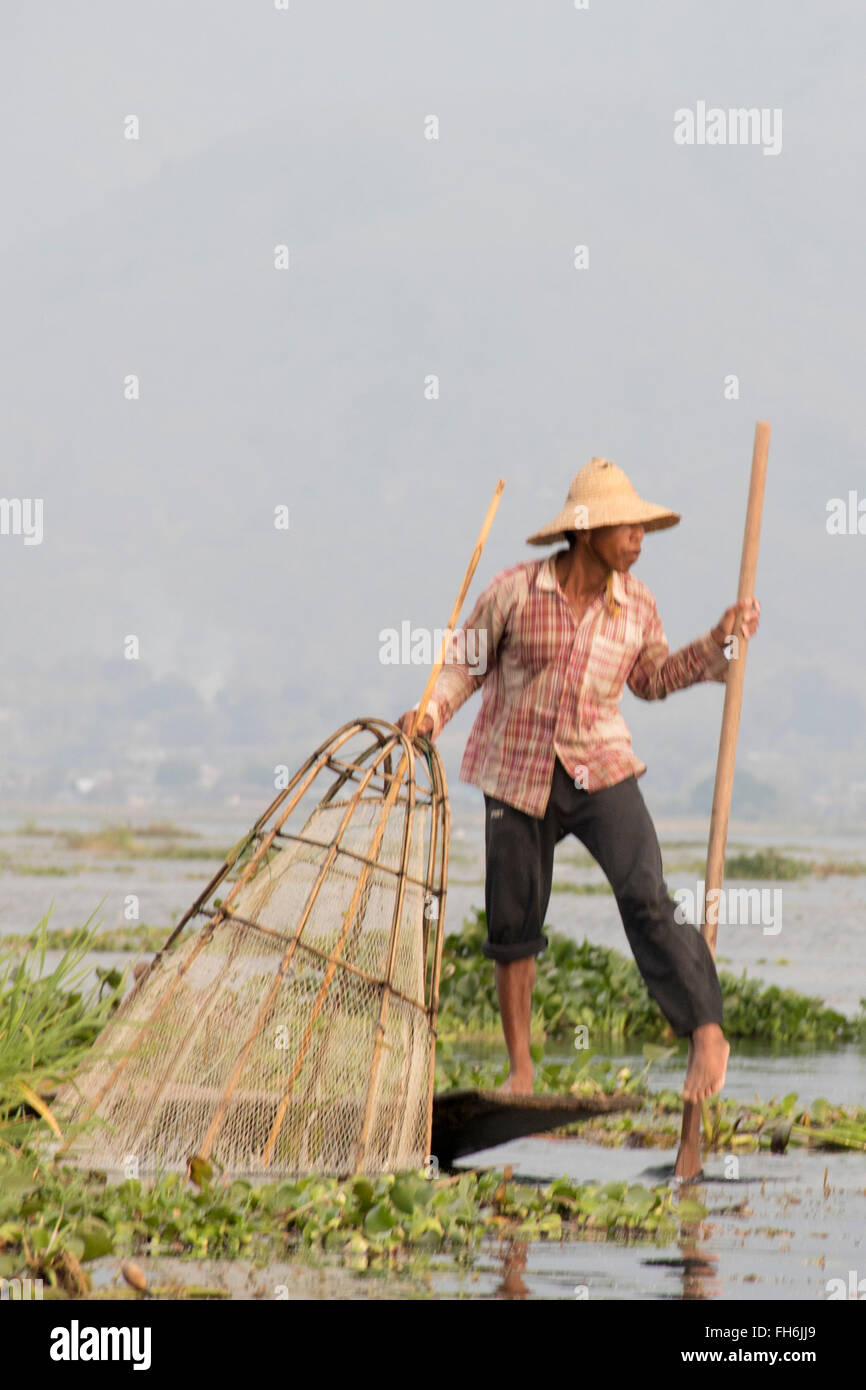 Fischer nutzt ein Bein zu Zeile während Angeln mit einem Haus konische net Inle-See, Myanmar gemacht Stockfoto