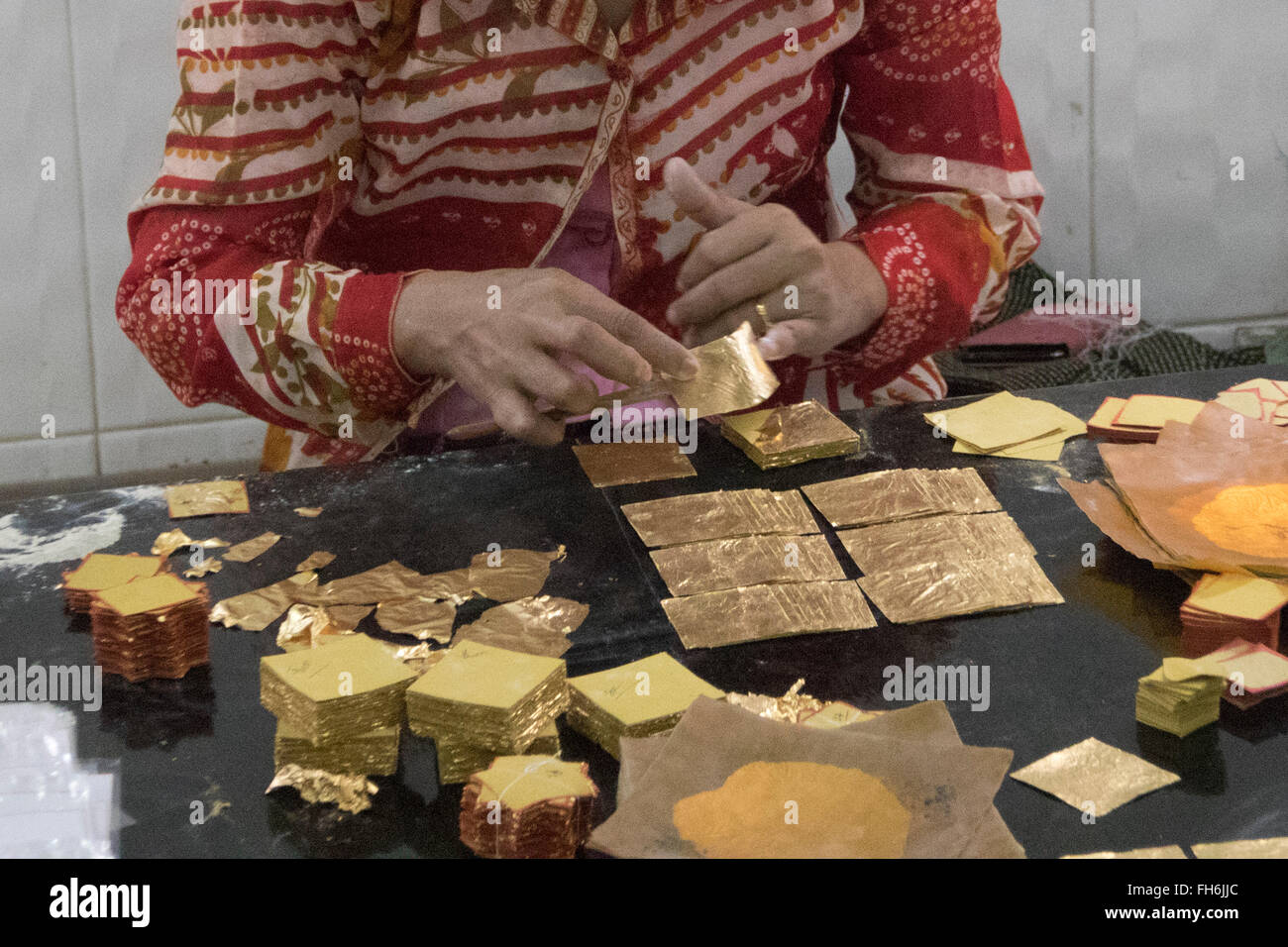 Verpackung der Einzelstücke von Blattgold zum Verkauf Mandalay, Myanmar Stockfoto