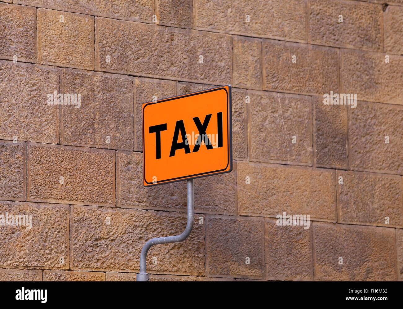 Taxischild auf dem Taxistand mit einer Wand eines alten Gebäudes als Hintergrund Stockfoto