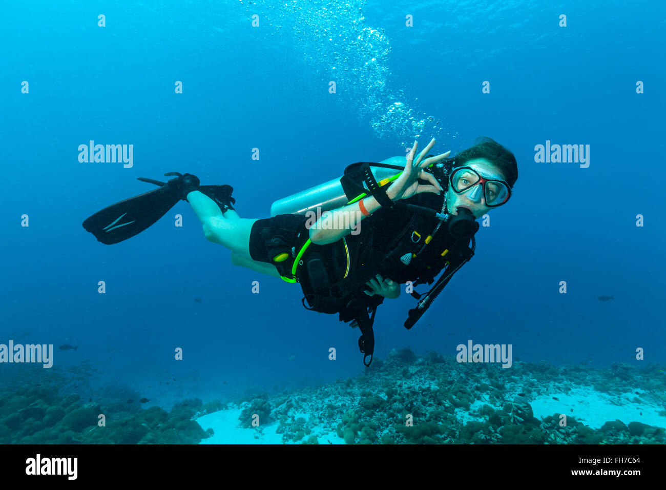 Weibliche Taucher unter Wasser zeigen ok signal Stockfoto