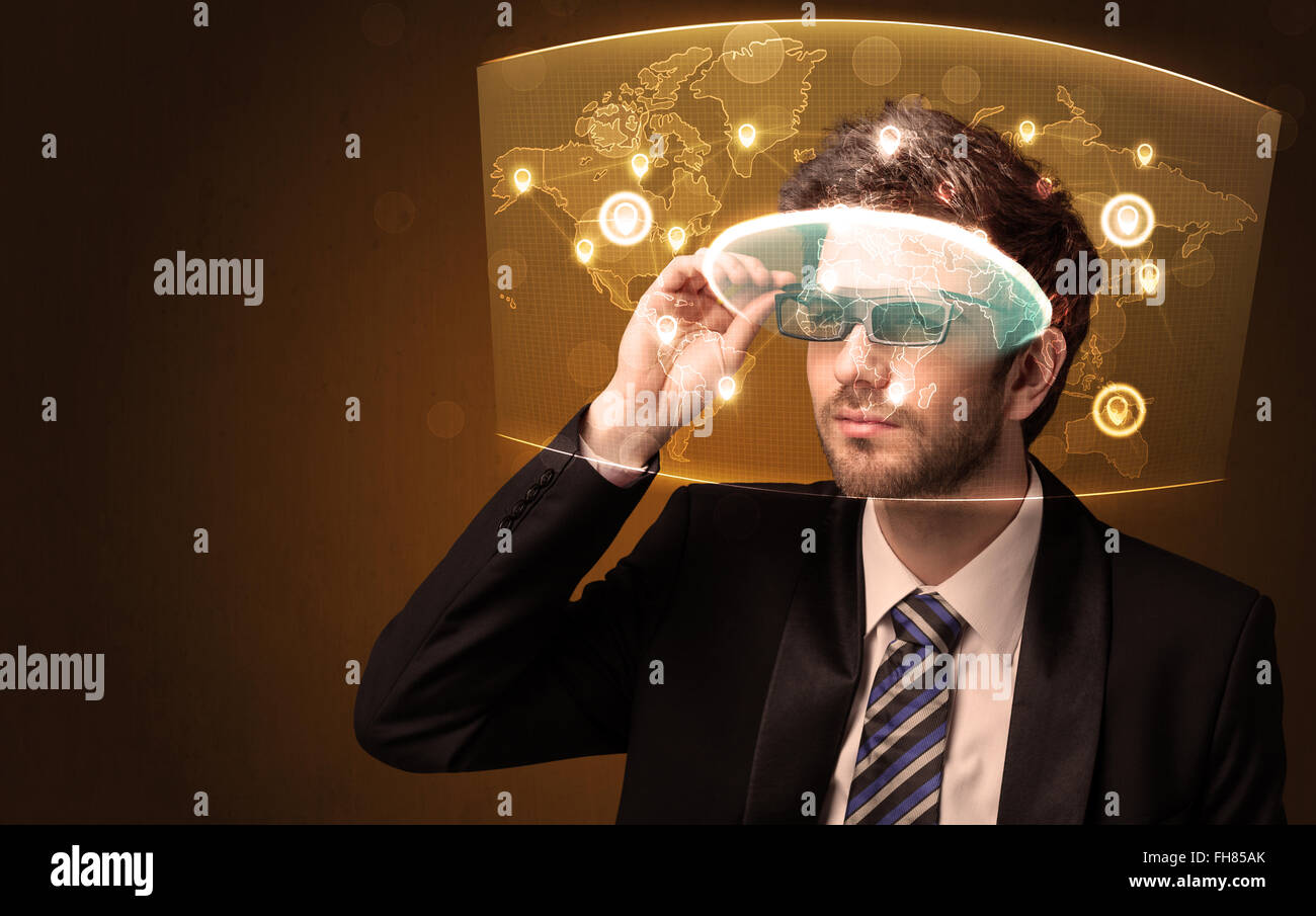 Junger Mann, Blick auf futuristische soziales Netzwerkkarte Stockfoto