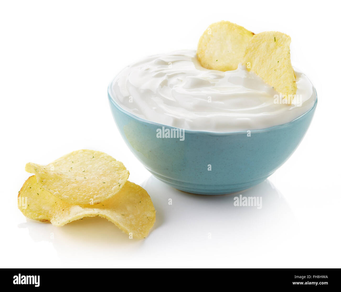 Kartoffel-Chips und Schüssel mit Sprung auf weißem Hintergrund Stockfoto