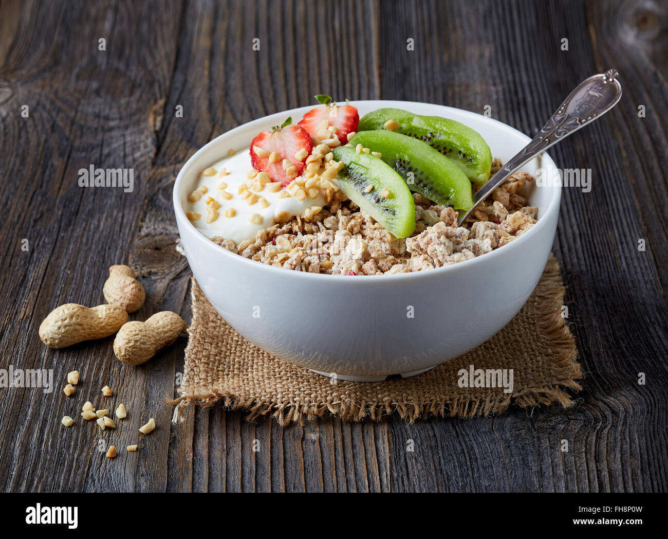 Gesundes Frühstück, Schüssel Müsli mit Joghurt und frischen Früchten auf Holztisch Stockfoto