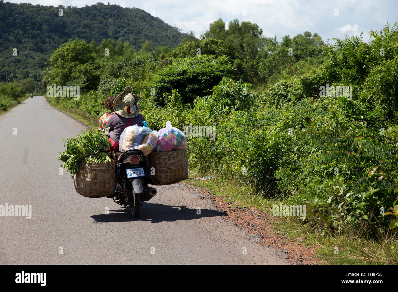 Mutter und Tochter auf einem Motorrad beladen mit waren außerhalb Sihanoukville, Kambodscha Stockfoto