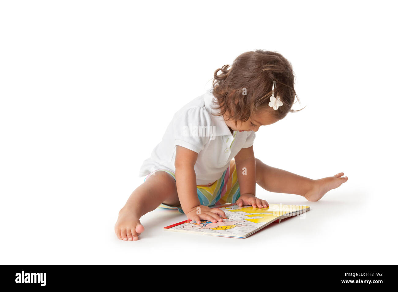 Kleinkind Mädchen vorgibt, ein Buch auf weißem Hintergrund Stockfoto