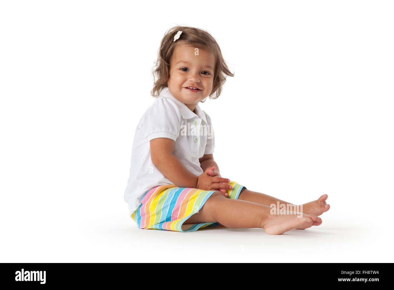 Glücklich Kleinkind Mädchen sitzen auf den Stock mit Blick in die Kamera auf weißem Hintergrund Stockfoto