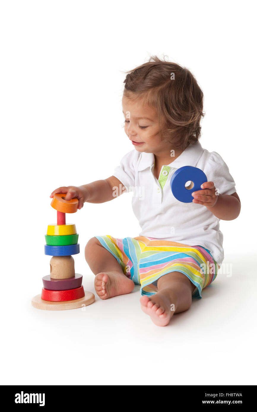 Kleinkind Mädchen spielen mit farbigen Steinen auf weißem Hintergrund Stockfoto