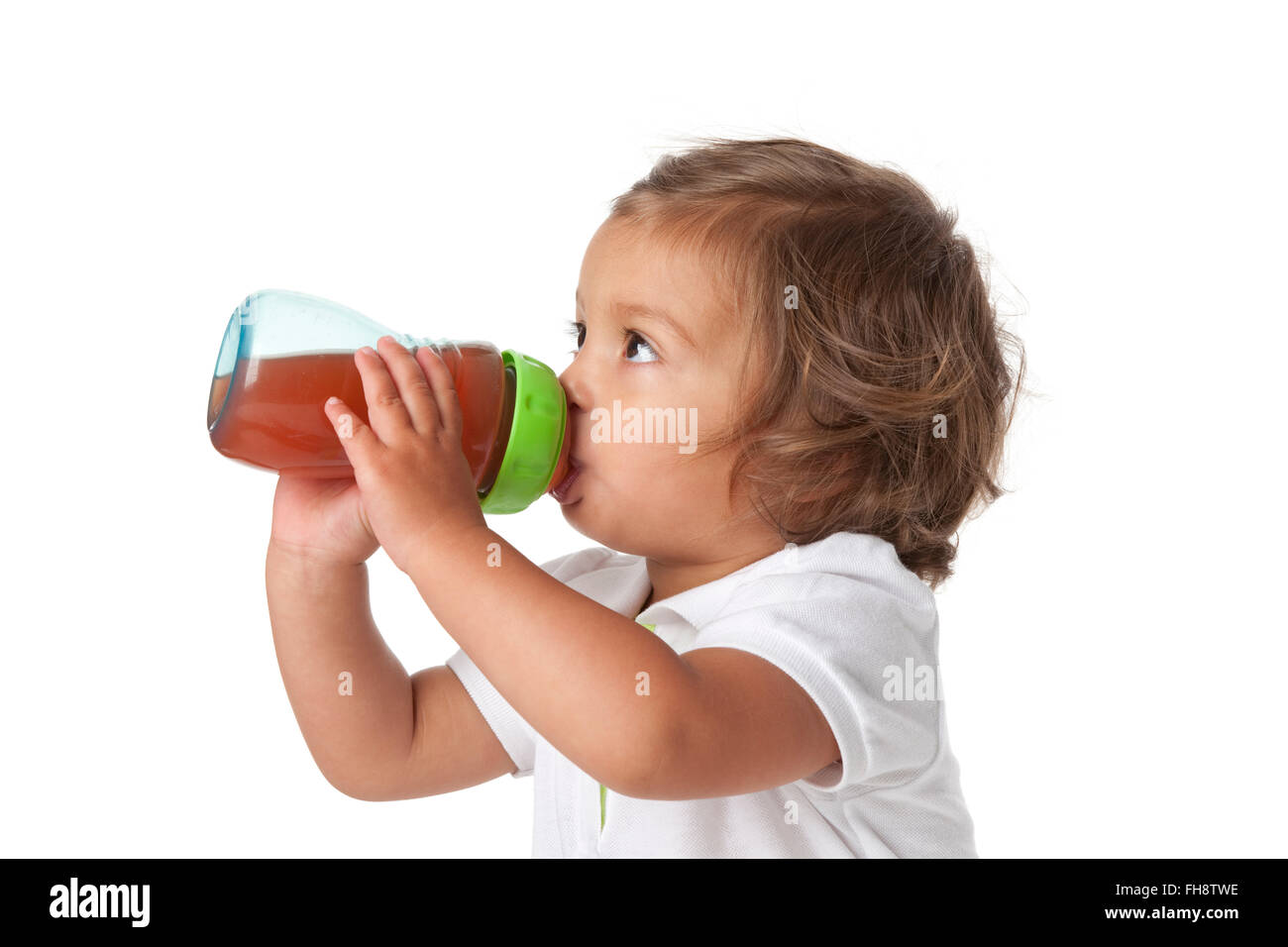Müde Kleinkind Mädchen trinken aus einer Flasche auf weißem Hintergrund Stockfoto