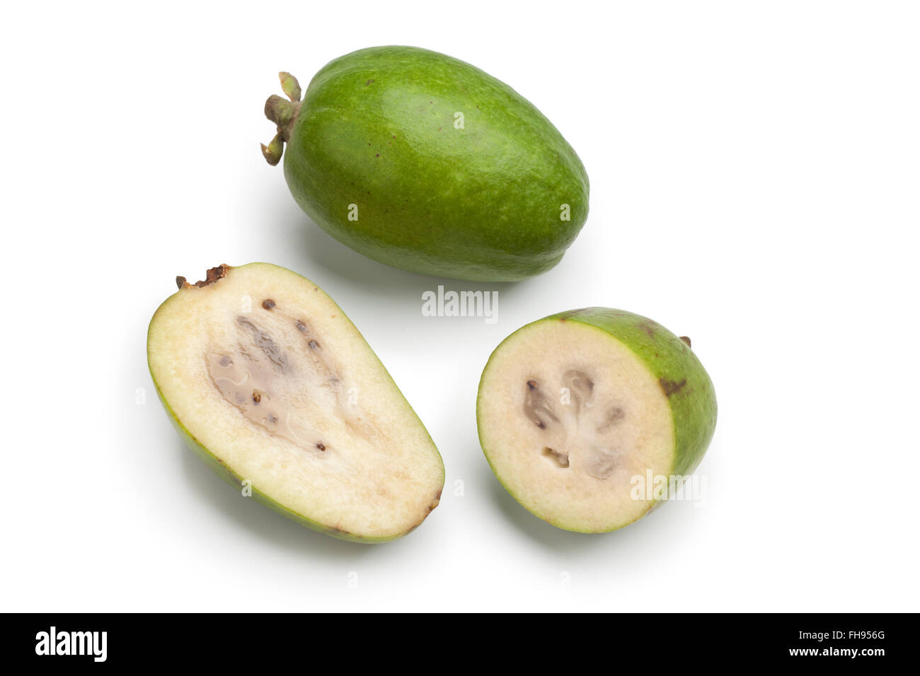 Ganze und halbe frische Feijoa Rohkost auf weißem Hintergrund Stockfoto