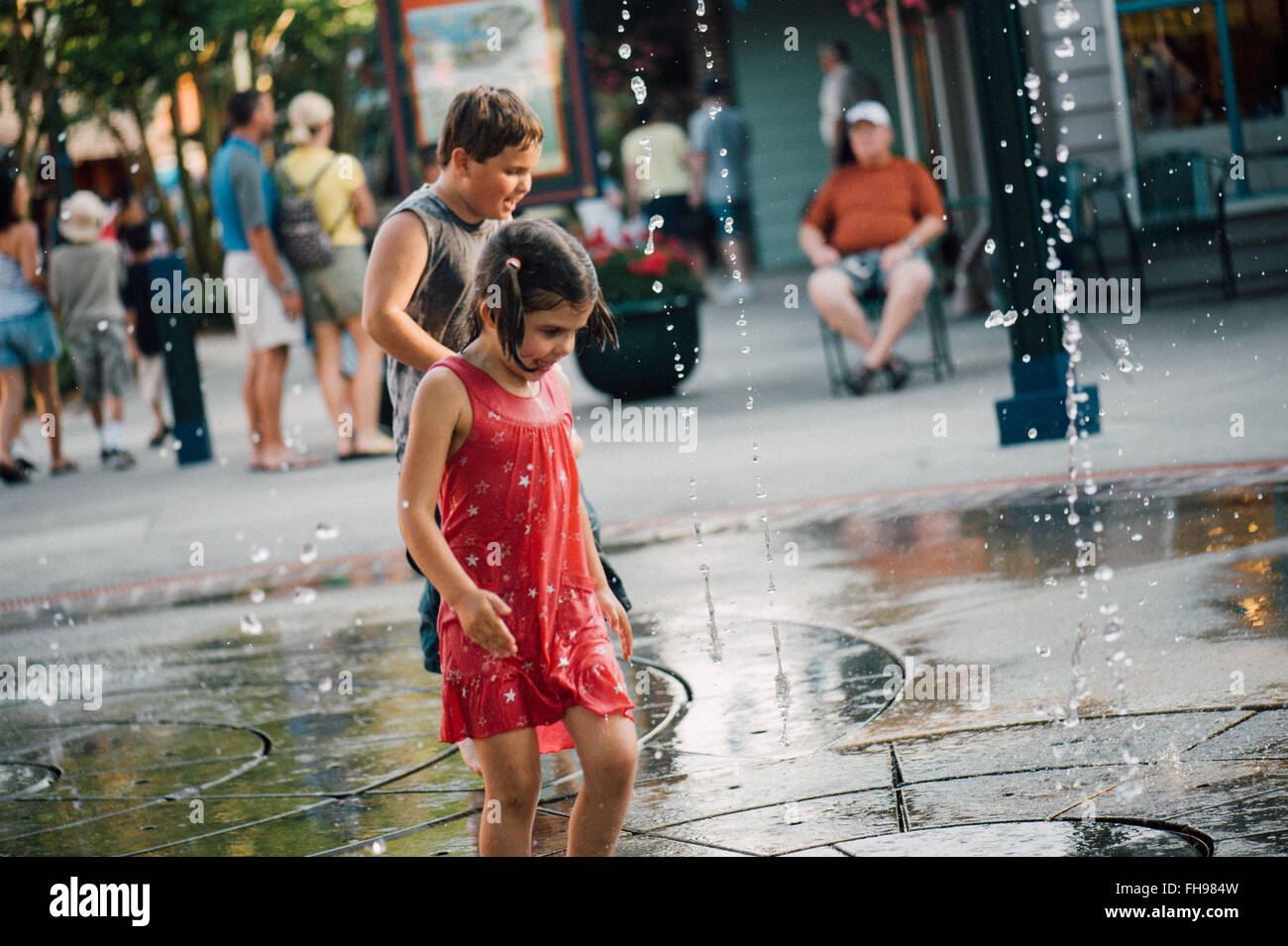 Junge Kinder haben Spaß beim Spielen mit Wasserfontänen im Vergnügungspark von Disney World in Florida uns zu Beginn des Sommers. Stockfoto